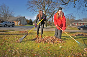 Sarah Shepherd and Brooke Porter (l-r) both juniors at MFHS and members of the Junior Optimist Club raked in a yard along Menomonee Avenue.